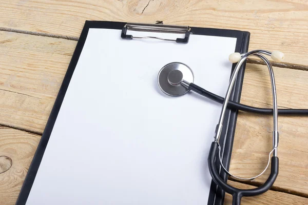 Werkplaats van een arts. Tablet PC, stethoscoop, zwarte pen op houten bureau achtergrond. Bovenaanzicht — Stockfoto