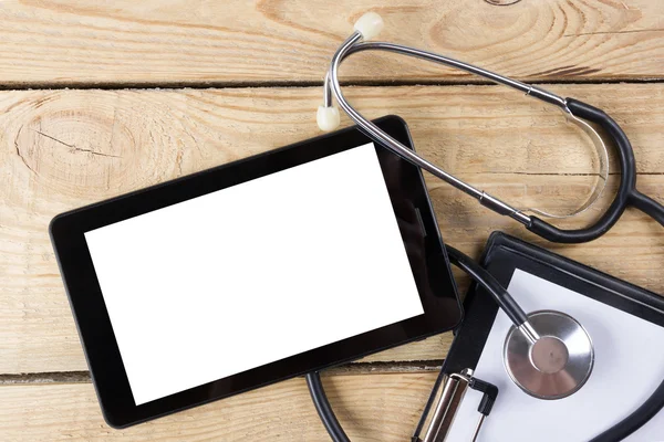 İşyeri bir doktor. Tablet, stetoskop, ahşap Resepsiyon arka plan üzerinde siyah kalem. Üstten Görünüm
