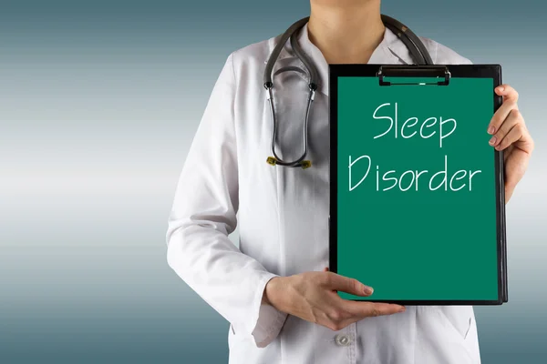 Расстройство сна - рука врача-женщины держит медицинский планшет и стетоскоп — стоковое фото