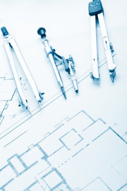 Architectural project, blueprints, blueprint rolls and divider compass, calipers, folding ruler on plans Engineering tools view from the top. Copy space. Construction background. Blue toned