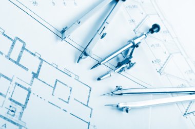 Architectural project, blueprints, blueprint rolls and divider compass, calipers, folding ruler on plans Engineering tools view from the top. Copy space. Construction background. Blue toned