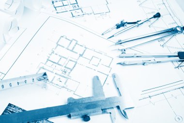 Architectural project, blueprints, blueprint rolls and divider compass, calipers, folding ruler on plans Engineering tools view from the top. Copy space. Construction background. Blue toned
