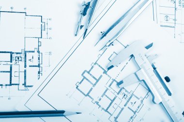 Architectural project, blueprints, blueprint rolls and divider compass, calipers, folding ruler on plans Engineering tools view from the top. Copy space. Construction background. Blue toned