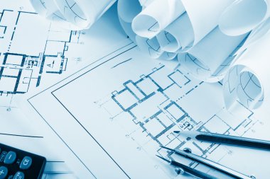 Architectural project, blueprints, blueprint rolls and divider compass, calipers, folding ruler on plans Engineering tools view from the top. Copy space. Construction background. Blue toned