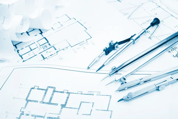 Architectural project, blueprints, blueprint rolls and divider compass, calipers, folding ruler on plans Engineering tools view from the top. Copy space. Construction background. Blue toned — Stock Photo, Image