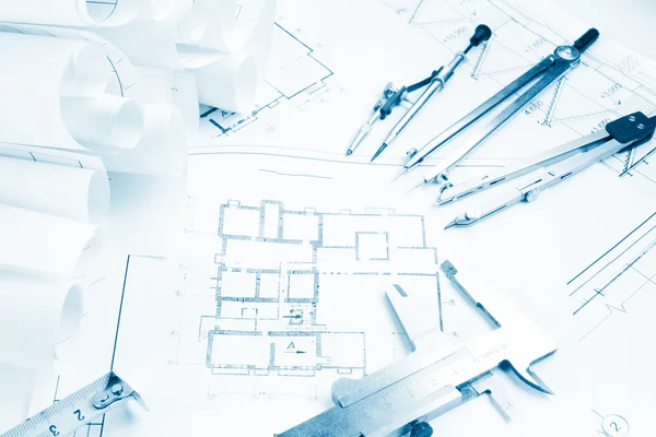 Architectural project, blueprints, blueprint rolls and divider compass, calipers, folding ruler on plans Engineering tools view from the top. Copy space. Construction background. Blue toned — 图库照片