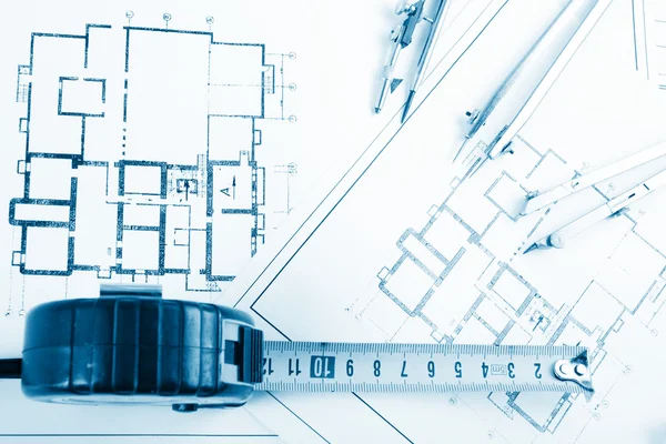 Architectural project, blueprints, blueprint rolls and divider compass, calipers, folding ruler on plans Engineering tools view from the top. Copy space. Construction background. Blue toned — Stockfoto