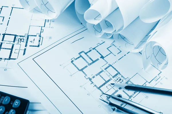 Architectural project, blueprints, blueprint rolls and divider compass, calipers, folding ruler on plans Engineering tools view from the top. Copy space. Construction background. Blue toned — Stock fotografie