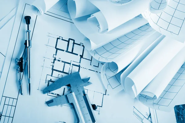 Architectural project, blueprints, blueprint rolls and divider compass, calipers, folding ruler on plans Engineering tools view from the top. Copy space. Construction background. Blue toned — Stockfoto