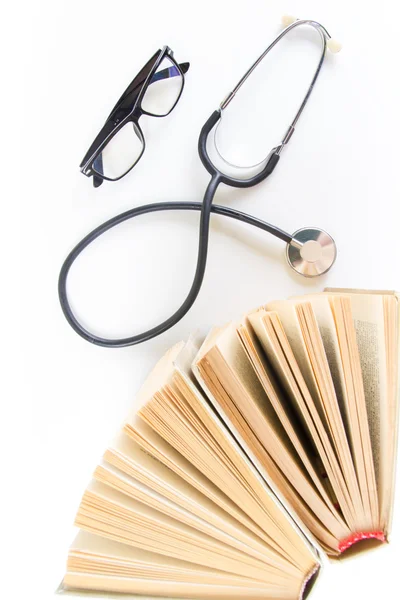 Open hardback books on the table, stethoscope and glasses. Top view. Medical professional education and information concept. Back to school, copy space. — Stock Photo, Image