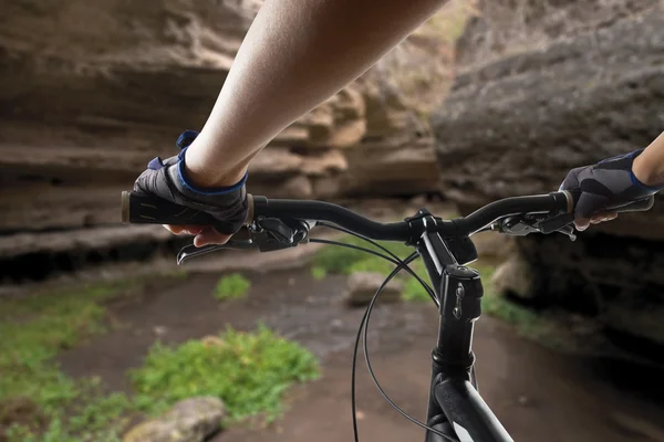 Hands in gloves holding handlebar of a bicycle. Mountain Bike cyclist riding single track. Healthy lifestyle active athlete doing sport — Stock Photo, Image