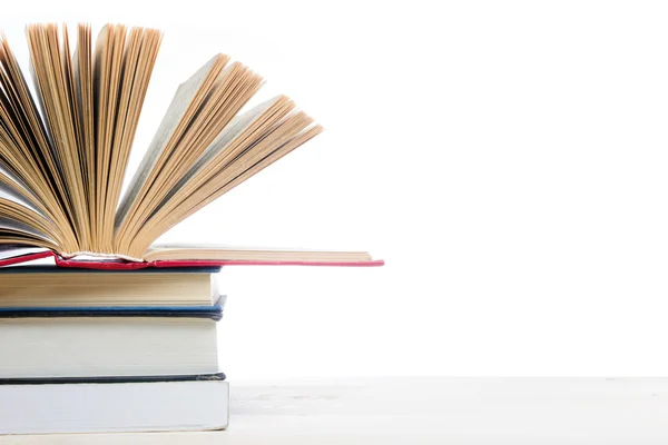 Pilha de livros sobre mesa de madeira isolada sobre fundo branco. De volta à escola. Espaço de cópia — Fotografia de Stock