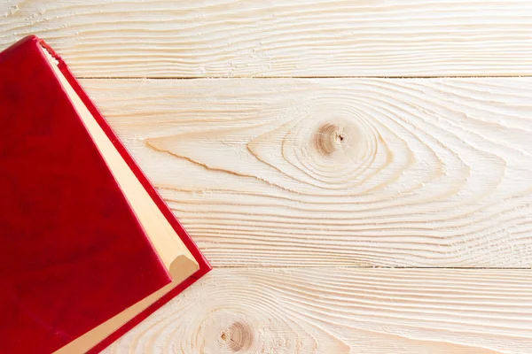 木製のテーブルに空の赤い本。平面図です。学校に戻るコピー スペース — ストック写真