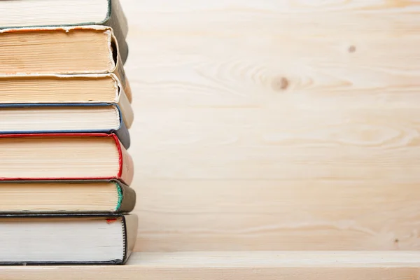 Ahşap masa üzerinde renkli kitap yığını. Okula dönüş. Kopya alanı