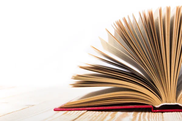 Open book on wooden table isolated on white background. Back to school. Copy space — ストック写真