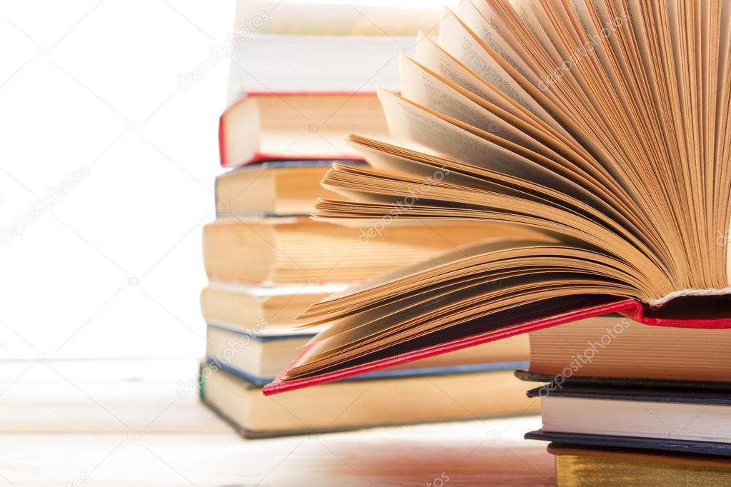 Stack of books on wooden table isolated on white background. Back to school. Copy space