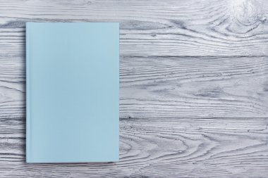 Ahşap dokulu arka plan üzerinde boş kitap kapağı. Kopya alanı