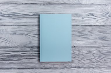 Ahşap dokulu arka plan üzerinde boş kitap kapağı. Kopya alanı