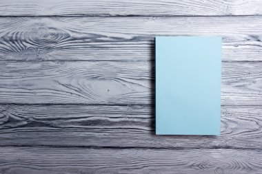 Ahşap dokulu arka plan üzerinde boş kitap kapağı. Kopya alanı