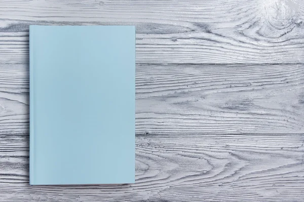 Ahşap dokulu arka plan üzerinde boş kitap kapağı. Kopya alanı