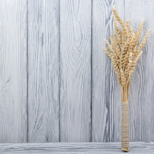 Ahşap masa buğday kulaklara. Ahşap arka plan üzerinde buğday demet. Hasat kavramı. — Stok fotoğraf