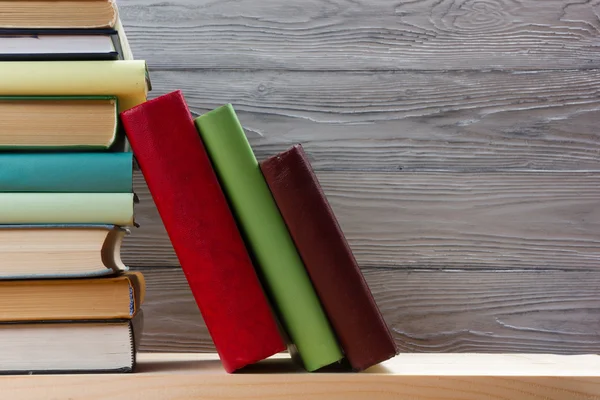 Ahşap masa üzerinde renkli kitap yığını. Okula dönüş. Kopya alanı