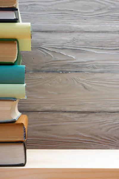 Ahşap masa üzerinde renkli kitap yığını. Okula dönüş. Kopya alanı