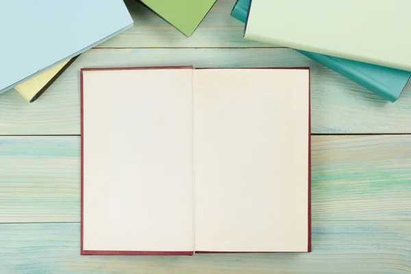 Ahşap dokulu arka plan üzerine açık kitap boş sayfaları ile. Kopya alanı