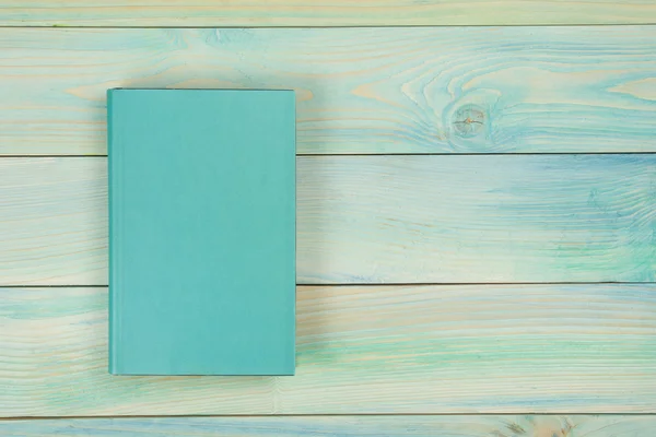 Ahşap dokulu arka plan üzerinde boş kitap kapağı. Kopya alanı