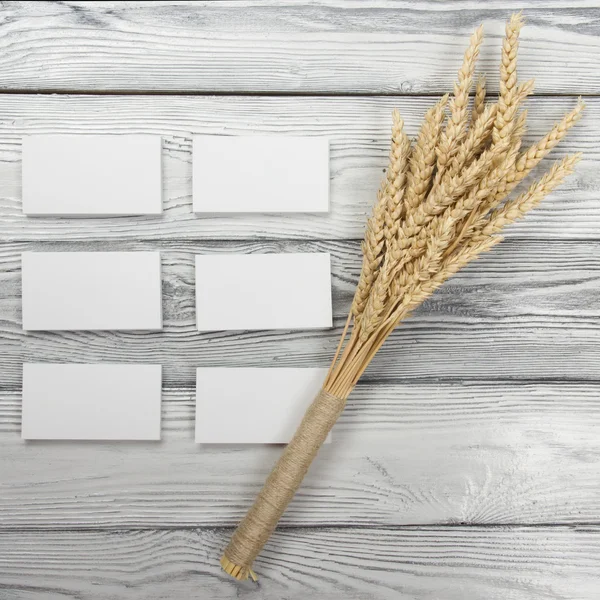 Oreilles de blé sur table en bois avec cartes de visite vierges. Gaine de blé sur fond de bois. Concept de récolte . — Photo
