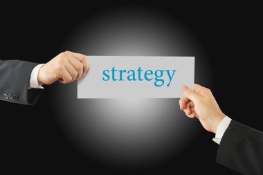 İki işadamı el kağıt üzerinde strateji kelime ile tutarak Close-Up