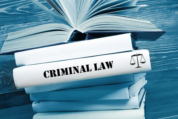 Βιβλίο με λέξη ποινικού δικαίου στο τραπέζι σε μια αίθουσα του Δικαστηρίου ή της επιβολής του γραφείου. Τονισμένο εικόνας — Φωτογραφία Αρχείου
