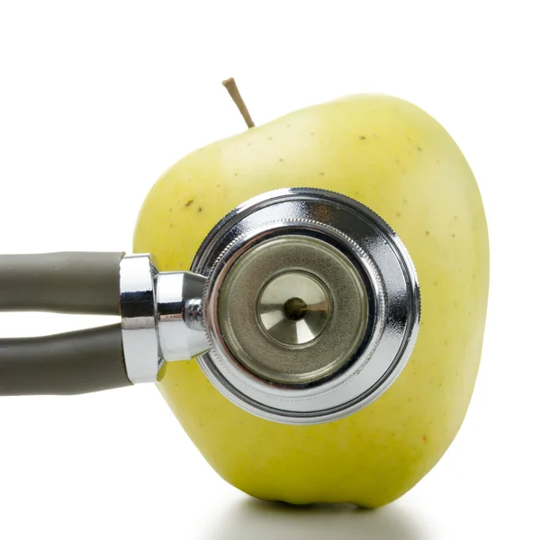 Green apple and medical stethoscope. Medical costs, financial concept — Stockfoto