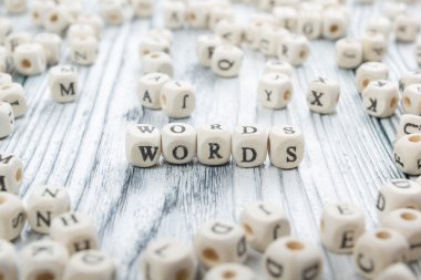Word made with block wood letter next to a pile of other letters over the wooden board surface composition. Block ABC