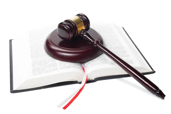 Книга законов с деревянными судьями молотком на столе в зале суда — стоковое фото