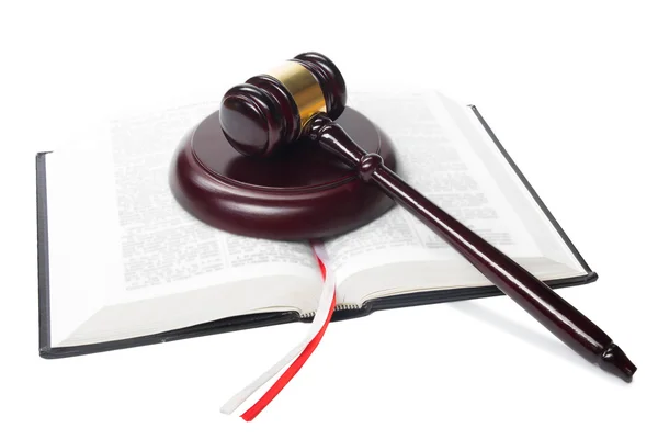 Law book with a wooden judges gavel on table in courtroom Stock Picture