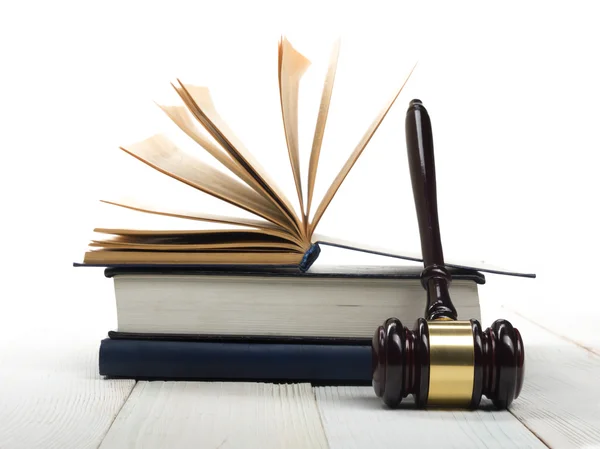 Livro de direito aberto com juízes de madeira martelo na mesa em um tribunal — Fotografia de Stock