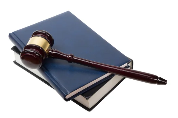 Bir mahkeme salonunda masada ahşap hakimler tokmak ile açık kanun kitabı