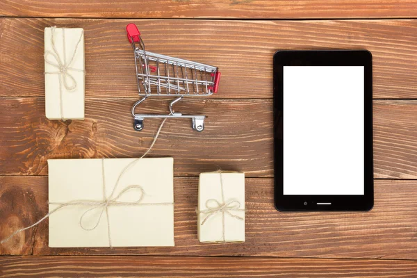 Online vásárlás koncepció - bevásárló kosár ürítése, laptop és tabletta pc, díszdobozban, rusztikus, fából készült háttér — Stock Fotó