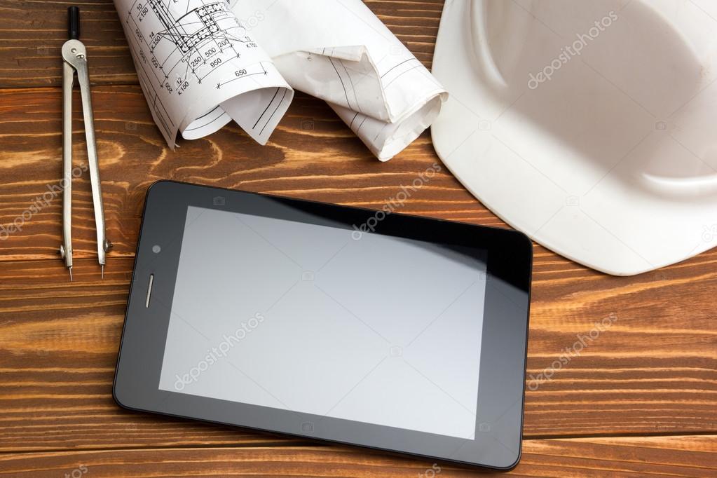 Workplace of architect - Architectural project, plan, blueprint rolls and tablet pc, pen, safety helmet on blank sheet paper. Civil Engineering or Construction background. Copy space for text