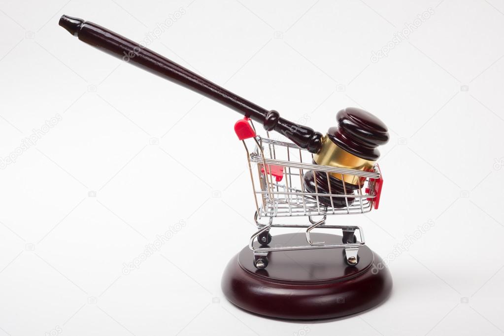 Judge gavel and shopping cart isolated on white background.