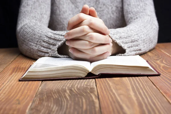 여자 손이 어둠 속에서 성경으로 기도 나무 테이블 — 스톡 사진