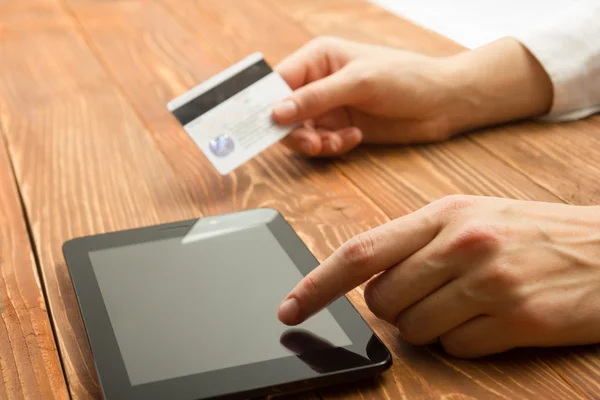Руки, що тримають номери кредитних карток на планшетному ПК, роблять онлайн оплату вдома дерев'яним столом. Концепція інтернет-магазинів. Вибірковий фокус . — стокове фото