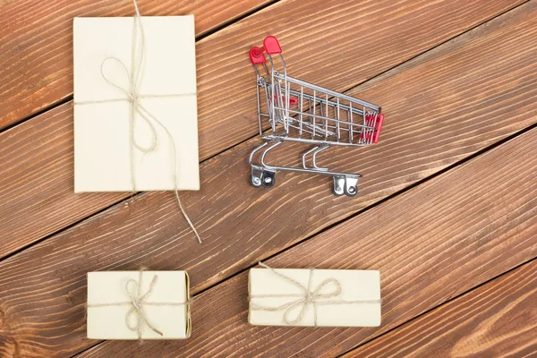 Концепция покупок в Интернете - Пустая корзина для покупок, ноутбук и планшет, подарочная коробка на деревенском деревянном фоне — стоковое фото