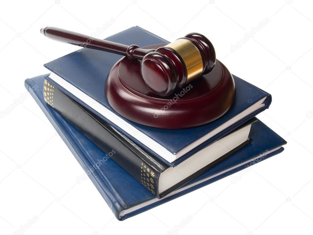 Law book with a wooden judges gavel on table in courtroom