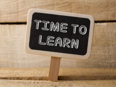 Chalkboard with  word time to learn on wood background
