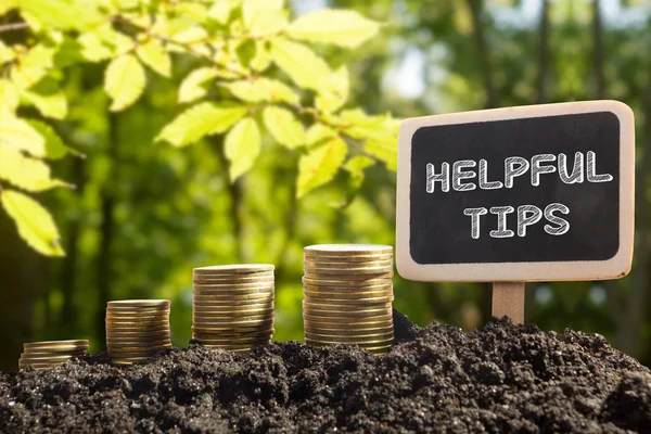 Helpful tips - Financial opportunity concept. Golden coins in soil Chalkboard on blurred urban background — Zdjęcie stockowe