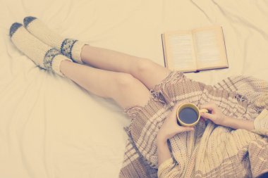 Eski kitap ve kahve ellerini, üstten bakış noktası yatağa kadın. Metin için yer kopyalayın. Yumuşak fotoğraf