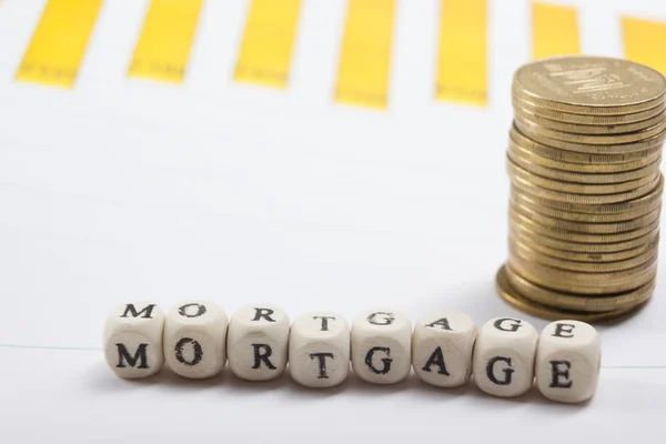 MORTGAGE word written on wood block, golden coins and chart — Stock Photo, Image