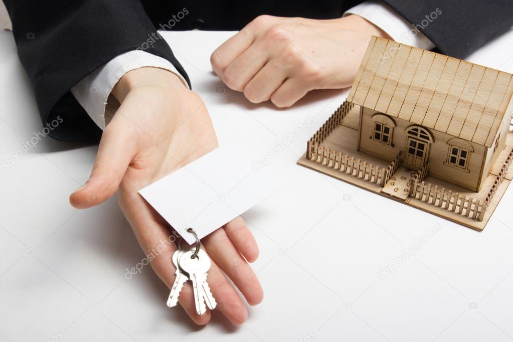 Real estate concept. Hands holding blank business card with keys.